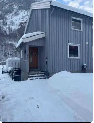 a small house with a door in the snow at Sentrumsnært hus in Rjukan