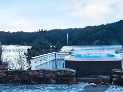 a hot tub on the side of a body of water at 8 person holiday home in Masfjordnes-By Traum in Masfjorden