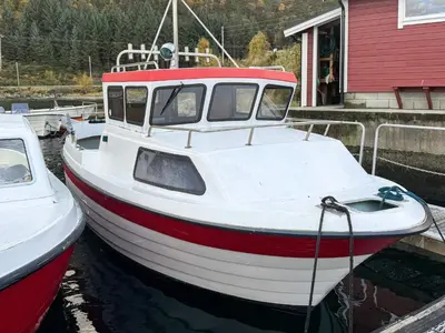a red and white boat sitting in the water at 3 person holiday home in Flatraket-By Traum in Barmen