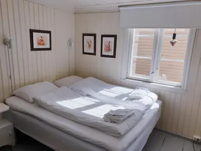 a white bed in a room with a window at Kvammehuset på Gamle Lærdalsøyri in Lærdalsøyri