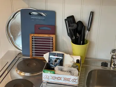 a kitchen counter with a sink with a box and utensils at Bakkebo Rampestreken in Åndalsnes