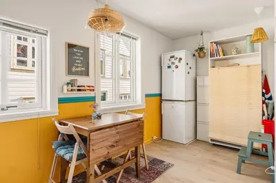 a kitchen with a refrigerator and a table in it at Dinbnb Apartments I Family Dream in Bergen I Playroom I Private Garden in Bergen