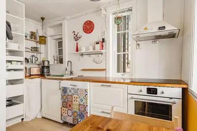 a kitchen with white appliances and a wooden table at Dinbnb Apartments I Family Dream in Bergen I Playroom I Private Garden in Bergen