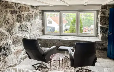 two chairs and a table in front of a window at 4 Bedroom Awesome Home In Nedre Vats in Stokka