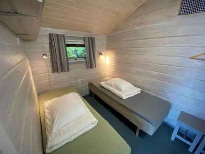 a small room with two beds and a window at Hole Hytter in Geiranger