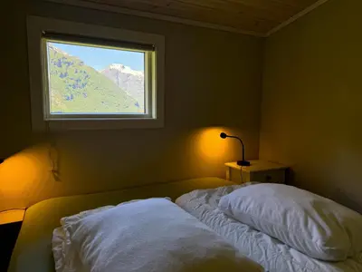 a bedroom with a bed and a window at Hole Hytter in Geiranger