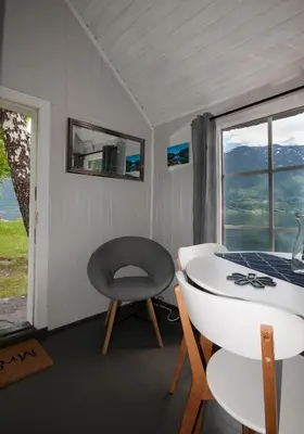 a room with a chair and a table and a window at Dalsøren Camping og hytter in Luster