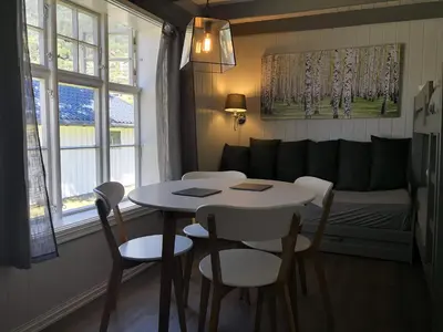 a living room with a table and chairs and a couch at Dalsøren Camping og hytter in Luster
