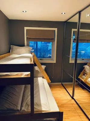 a bedroom with two bunk beds and a window at Moderne rekkehus, god standard. in Ålesund