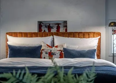 a bed with a wooden headboard and pillows at Vertshuset Konow in Bergen
