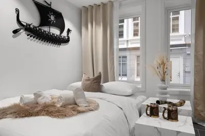 a white bedroom with a bed with a furry blanket at Renovated 2024 - Viking inspired - Behind bryggen in Bergen