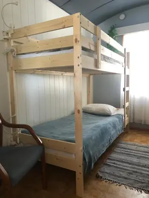 a wooden bunk bed in a room with a couch at Rena Hostel in Rena