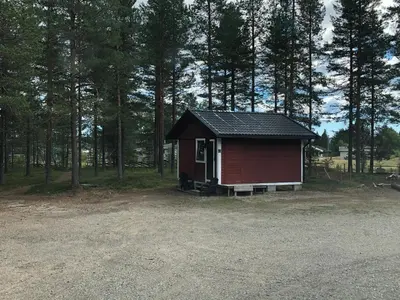 a small red shed in the middle of a forest at Rena Hostel JOHANNES in Rena