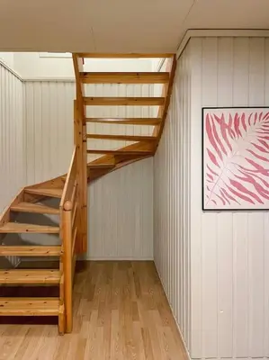 a wooden staircase in a room with a painting at Spacious villa with view - 5BR - FREE parking - Great Wi-Fi in Bergen