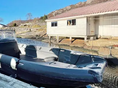 a boat is parked in the water next to a house at 6 person holiday home in Dalsøyra-By Traum in Dalsøyra