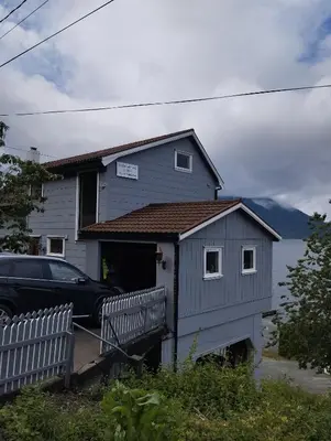 a small house with a fence in front of a house at Sveciu namai in Vikedal