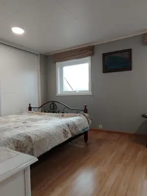 a bedroom with a bed and a window at Sveciu namai in Vikedal
