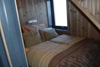 a small bed in a room with a window at Pow Panorama - High standard Mountain home in Sogndal