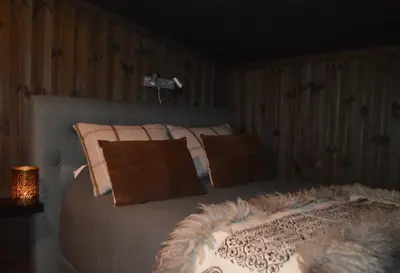 a bedroom with a bed with pillows and a lamp at Pow Panorama - High standard Mountain home in Sogndal