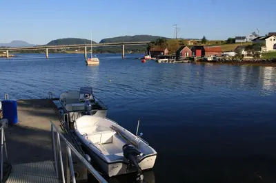 a boat is docked at a dock in the water at Åkviktunet hytte nord in Averoy