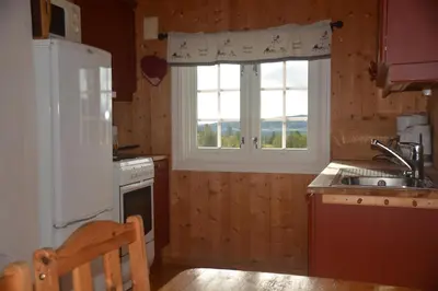 a kitchen with a white refrigerator and a window at Einkjerrbu cabin by Norgesbooking - in Svingvoll