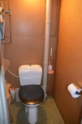 a small bathroom with a toilet with a black seat at Einkjerrbu cabin by Norgesbooking - in Svingvoll