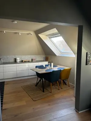 a kitchen with a table and chairs and a skylight at Modern Penthouse in Sandviken in Bergen