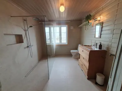 a bathroom with a shower and a sink and a toilet at Fagerstrand, storhytte ved Bygdin i Jotunheimen in Beitostøl