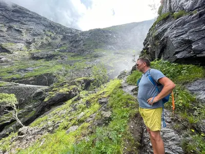 a man standing on the side of a mountain at Bakkebo Trollstigen in Åndalsnes