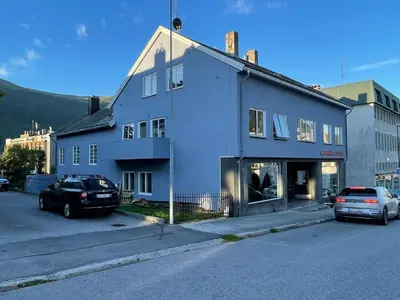 a white building with cars parked in front of it at Bakkebo Trollstigen in Åndalsnes