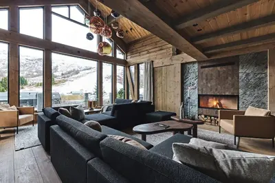 a living room with couches and a fireplace at Chalet Strandafjellet in Stranda