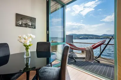 a dining room with a table and a view of the water at New! Sea front apt. with terrace above the sea! in Bergen