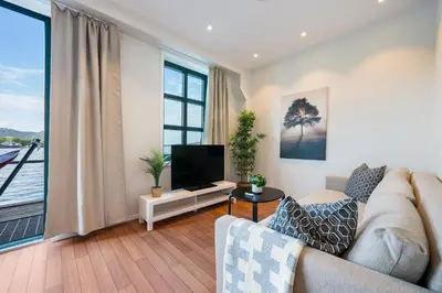a living room with a couch and a flat screen tv at New! Sea front apt. with terrace above the sea! in Bergen