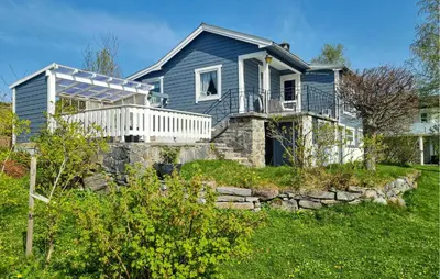 a blue house with a porch and a stone wall at 2 Bedroom Cozy Home In Skodje in Skodje