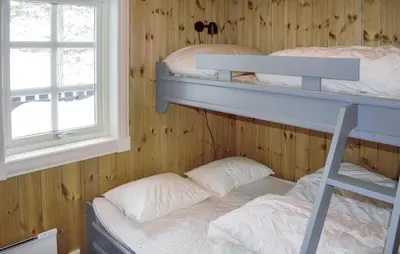 a bedroom with two bunk beds and a window at 4 Bedroom Nice Home In Engerdal in Kvisla