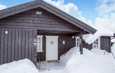 a wooden cabin with snow around the door at 4 Bedroom Nice Home In Engerdal in Kvisla