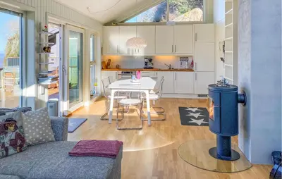 a living room with a couch and a table at 2 Bedroom Lovely Home In Raudeberg in Raudeberg