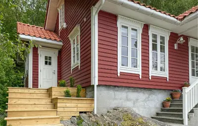 a red house with a white door and stairs at Amazing Home In Eiksund With Kitchen in Eiksund