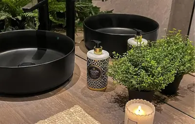 a table with two black buckets and a candle and plants at Amazing Apartment In Noresund With Wifi in Noresund