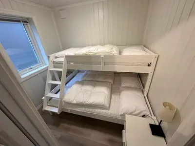 two bunk beds in a small room with a window at Rorbu i Gilsvågen - Egen Brygge - Båtutleie in Blænes