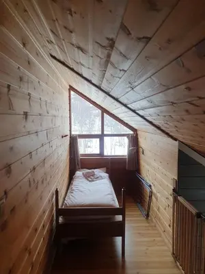 a room with a bed in a wooden room with a window at Kvamskogen & Hardanger Holliday homes in Norheimsund