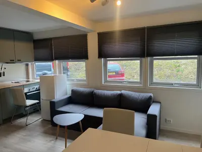a living room with a couch and a kitchen at Trolltun, Frystevegen 4 in Ulvik