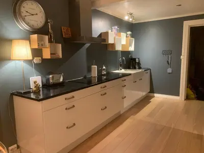 a kitchen with a sink and a clock on the wall at Stryn Golden Resort-«Skulehuset» in Stryn