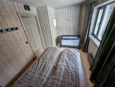 a small room with two beds and a window at Ski in/out Appartment Hemsedal in Hemsedal