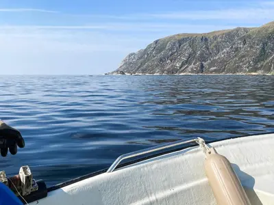 a boat on a body of water with a mountain at 8 person holiday home in Bremanger in Grotle