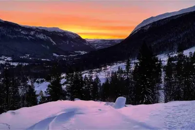 a view of a snowy mountain with a sunset in the background at Leilighet i Uvdal med nydelig utsikt in Sønstebø