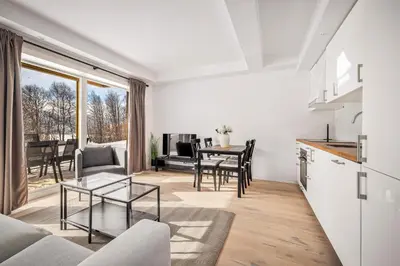 a kitchen and living room with a table and chairs at Gullstein in Geilo