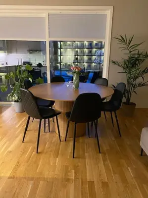 a dining room table with chairs and a vase on it at Strøken leilighet inkl parkeringskjeller. in Trondheim