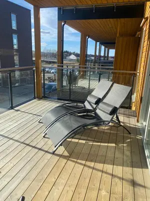 a bench sitting on the deck of a building at Strøken leilighet inkl parkeringskjeller. in Trondheim
