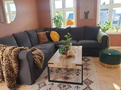 a living room with a blue couch and a table at Romslig og særegent hus in Skodje